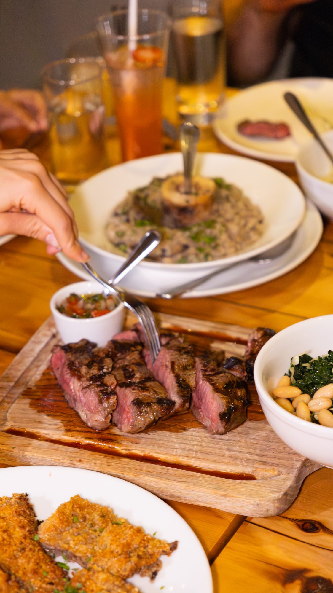 Bife de costilla a la parrilla, cortado en la mesa