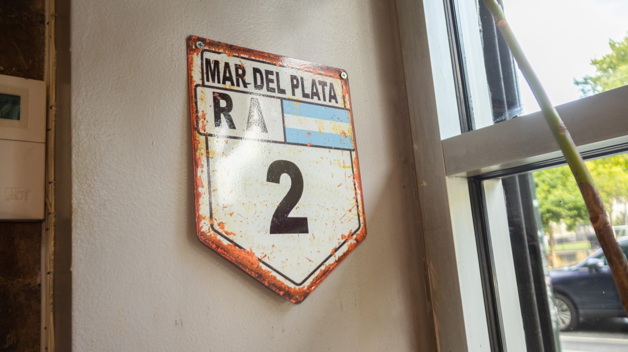 Cartel vintage de la Ruta 2 a Mar del Plata en la pared de Porteño