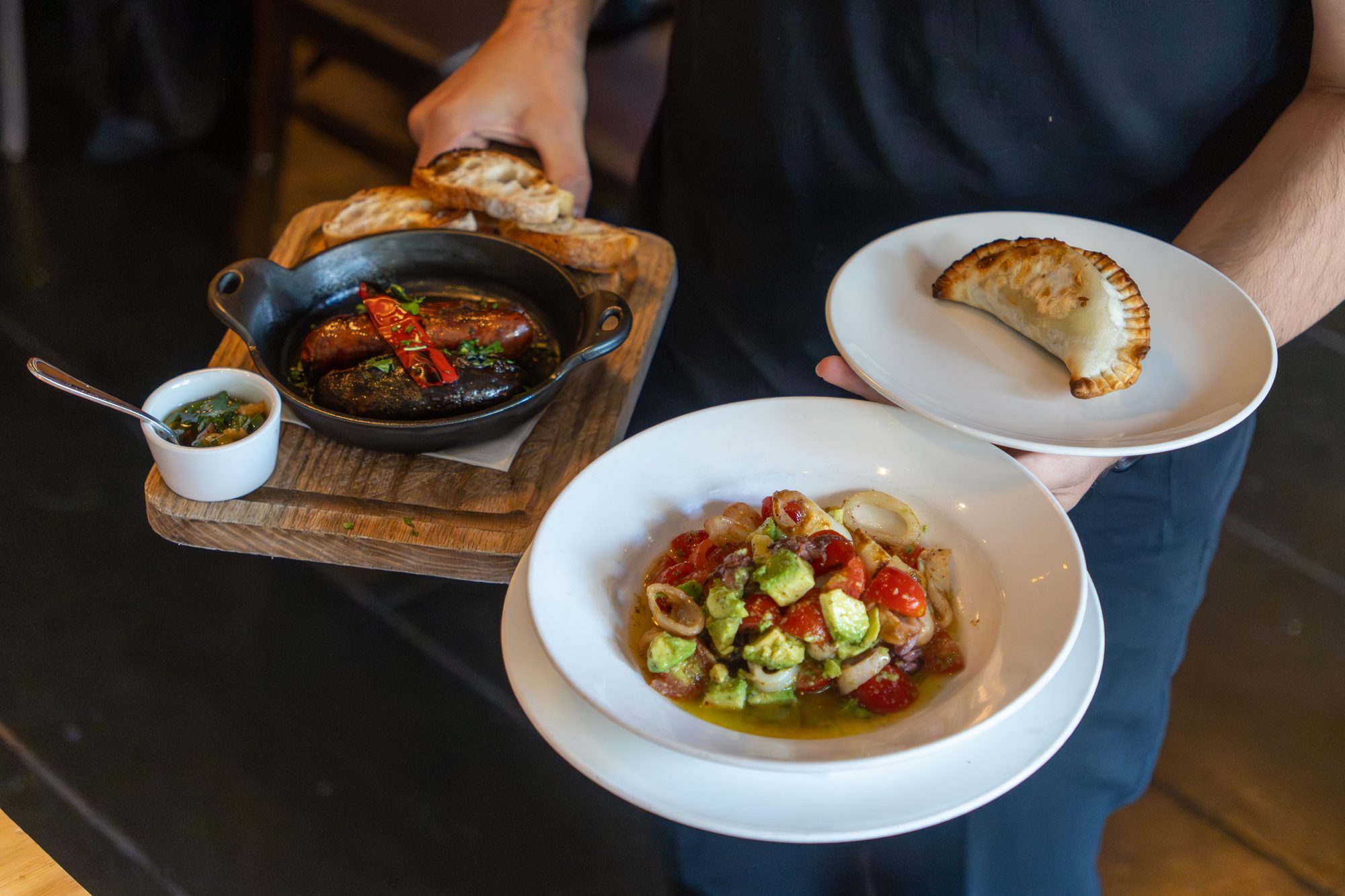 Chorizo criollo y morcilla, una empanada, y una entrada de mariscos