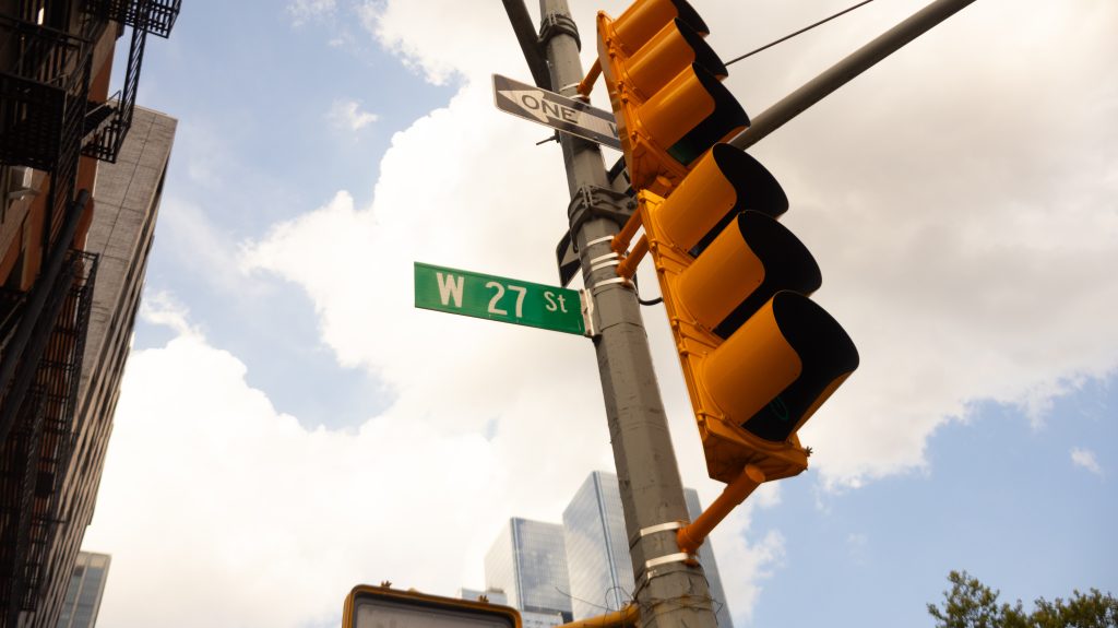 A traffic light and street sign at the corner of W 27th Street in Manhattan, near Hudson Yards, NYC.